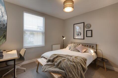 Bright, neatly styled double bedroom with a com...