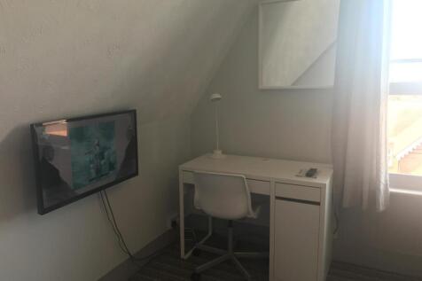 Bright workspace with wall-mounted TV and desk...