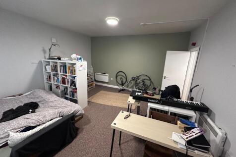 Spacious bedroom with a double bed, open floor ...