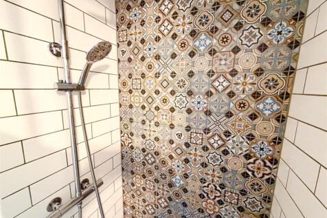 Modern shower with stylish patterned tiling...