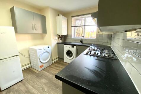 Modern galley kitchen with dark worktops, grey ...