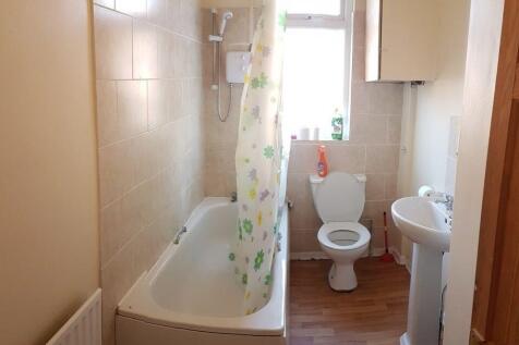 Bright, clean bathroom with a tub and overhead ...