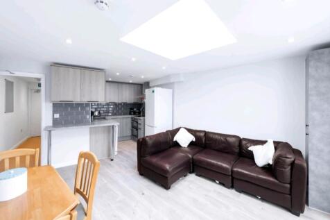 Bright modern living area with skylight and sof...