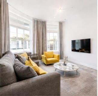 Bright lounge with large windows and modern TV...