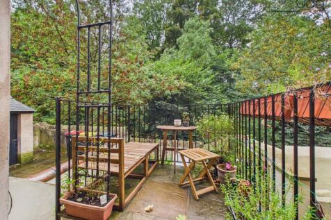A Raised Garden Terrace With A Woodland Backdrop