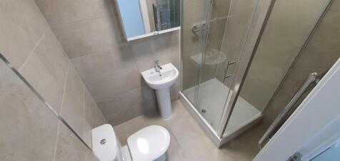 Neat modern bathroom featuring a corner glass s...