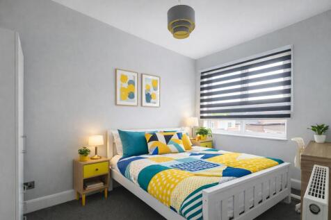 Bright, modern double bedroom with a colorful d...