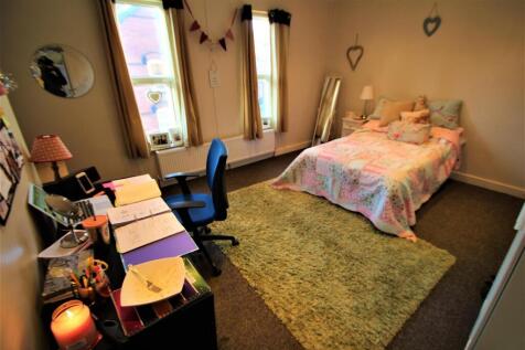A cozy and well-lit bedroom featuring a double ...