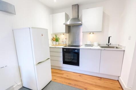 A bright and clean kitchen featuring modern whi...