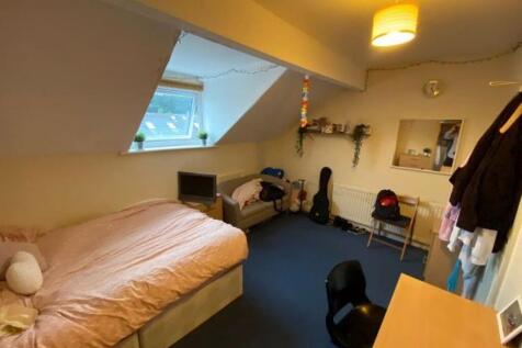 Cozy attic-style bedroom with a single bed, bui...