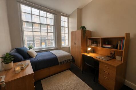 Bright bedroom with large desk and ample storag...