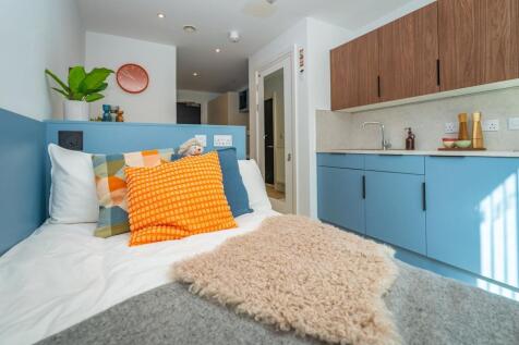Vibrant studio with stylish blue kitchen units...
