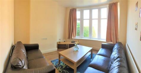 Bright, neutral living room with two sofas faci...