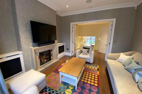 Bright, stylish living room with a feature fire...