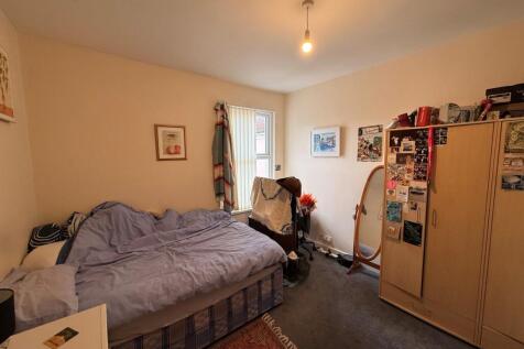 Bright, neatly furnished bedroom with a comfort...