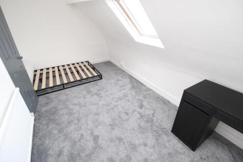 Bright attic bedroom with plush carpet and desk...