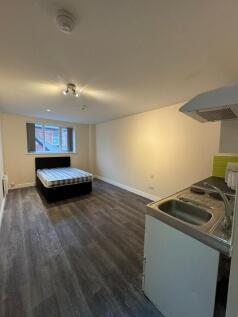 A spacious, well-lit living area with large win...