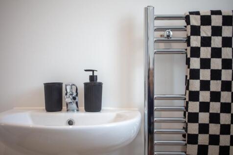 Modern sink and heated towel rail in bathroom...