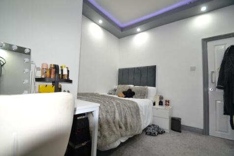 Bright, modern double bedroom with a plush grey...