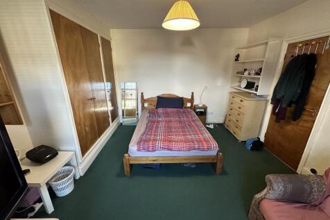 Neat bedroom with a central wooden double bed, ...