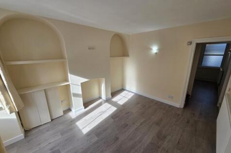 Bright living room with built-in shelving and w...