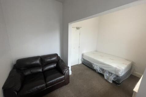 Compact bedroom with a comfortable dark leather...