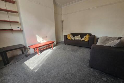 A spacious and neatly maintained living room fe...