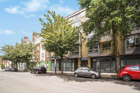 Tree-lined urban street with modern brick building