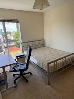Bright bedroom with a metal double bed frame, a...