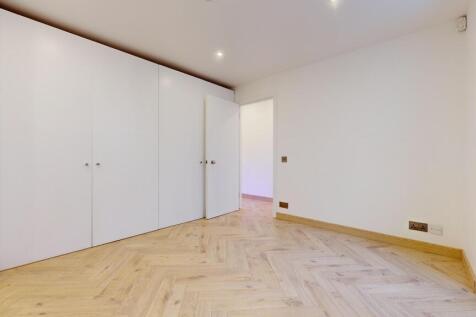 Bright modern bedroom with ample built-in stora...