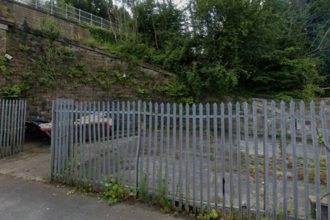 A large plot of land, with metal fencing around it.