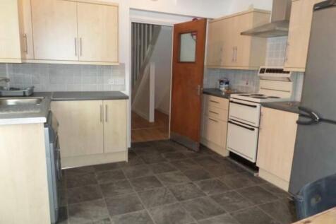 Well-equipped kitchen with modern light-wood ca...