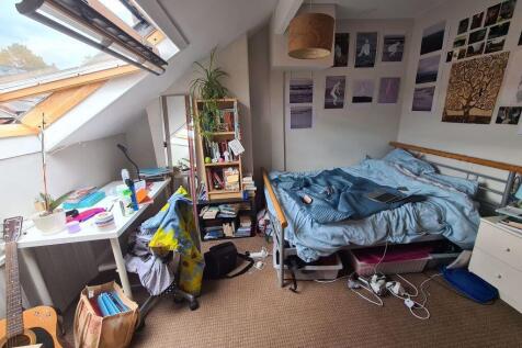 A cozy bedroom with a bed, some furniture, and ...