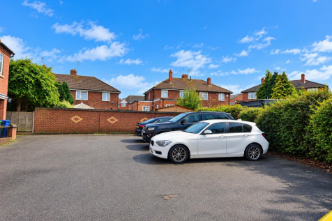 Sunny Suburban Driveway with Parked Cars.png
