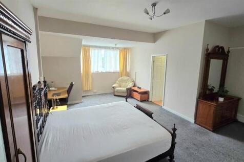 Spacious master bedroom with double bed and des...