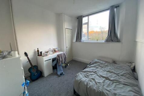 Bright bedroom with large window and study desk...