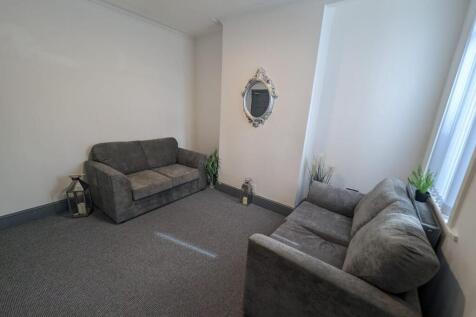 Bright, neutrally decorated living room with tw...