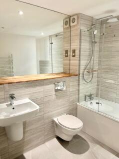 Modern bathroom with sleek tiles and large mirr...