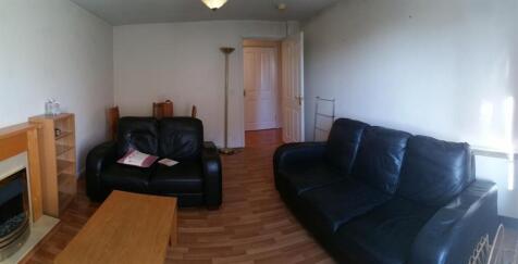 Bright, simply furnished living room with two l...
