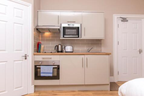 Modern kitchenette with sleek integrated applia...