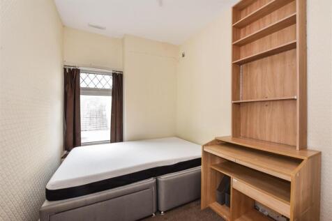 Bright bedroom with large desk and shelving...