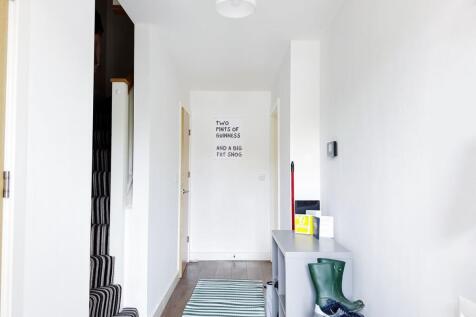 Bright, minimalist hallway with white walls, st...