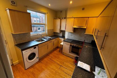 Bright galley-style kitchen with wooden cabinet...