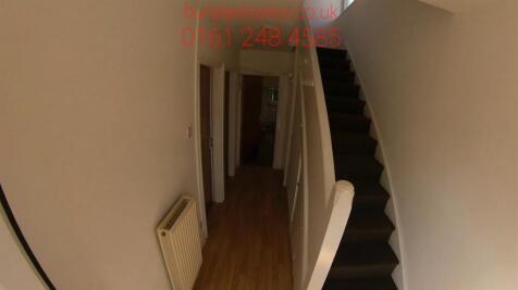 Narrow interior hallway with wooden flooring, a...