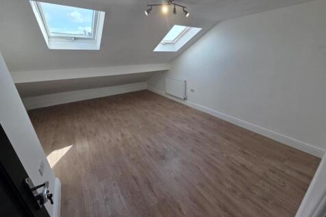 Bright attic room with stylish wood flooring...