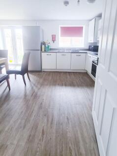 Bright modern kitchen with white cabinets, inte...