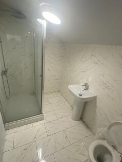 Bright and modern bathroom featuring white marb...