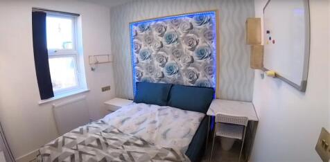 Cozy double bedroom with patterned feature wall...