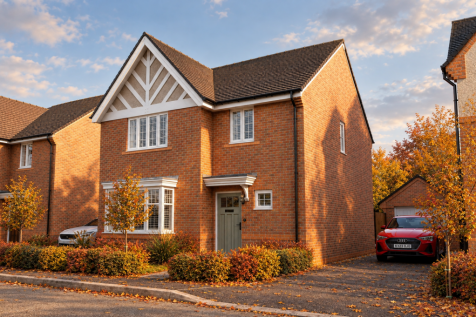 A two-story red brick house with a gabled roof stands in the foreground