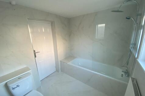 A clean and modern bathroom featuring a bath an...